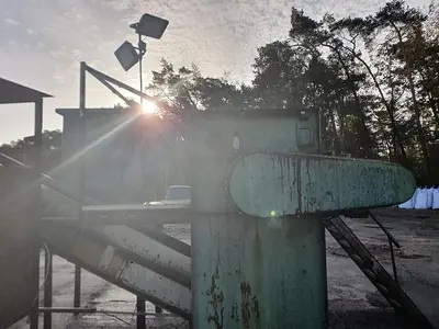 Briquetting machine for the production of charcoal briquettes including a hot air generator and conveyor