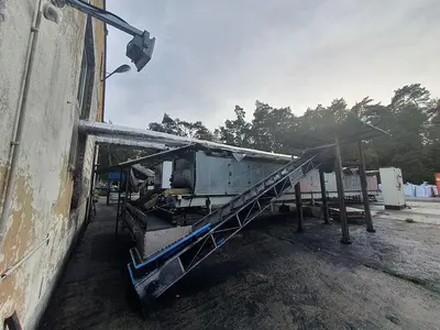 Briquetting machine for the production of charcoal briquettes including a hot air generator and conveyor