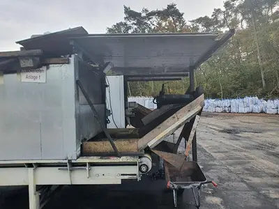 Briquetting machine for the production of charcoal briquettes including a hot air generator and conveyor
