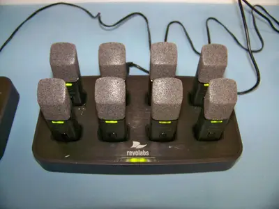 (24) Revolabs Wireless Lapel Mics / Microphones with (3) Charging Bases and (5) Replacement Mics that are NEW IN BOX