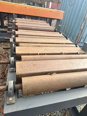 Used Grey Powered Conveyor with load staging on side
