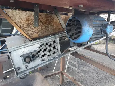 Briquetting machine for the production of charcoal briquettes including a hot air generator and conveyor