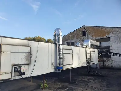Briquetting machine for the production of charcoal briquettes including a hot air generator and conveyor
