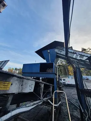 Briquetting machine for the production of charcoal briquettes including a hot air generator and conveyor