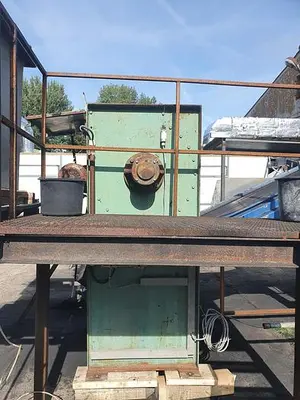 Briquetting machine for the production of charcoal briquettes including a hot air generator and conveyor