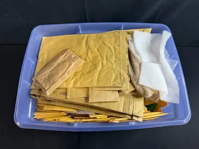 Collection of Padded Mailing Envelopes and Bubble Mailers in Storage Bin