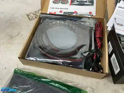 Box of various car parts and accessories including: red and black rearm rest covers, Chevy...