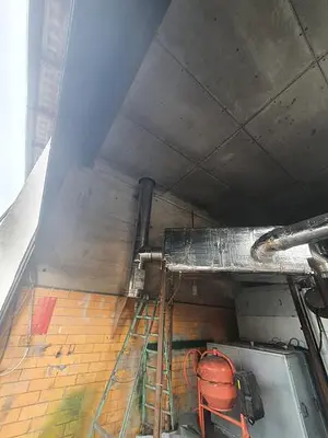 Briquetting machine for the production of charcoal briquettes including a hot air generator and conveyor