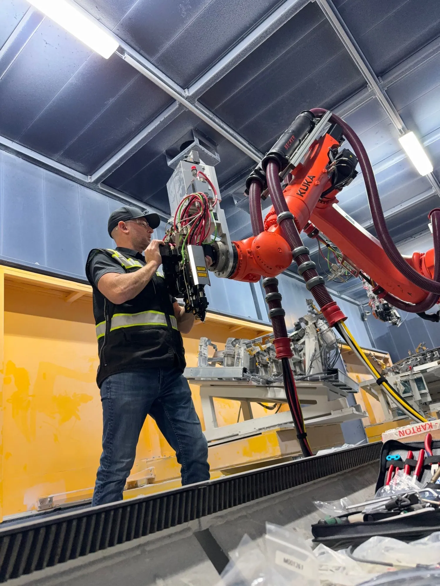 Technician working on robotic laser welding integration system inside an automated cell