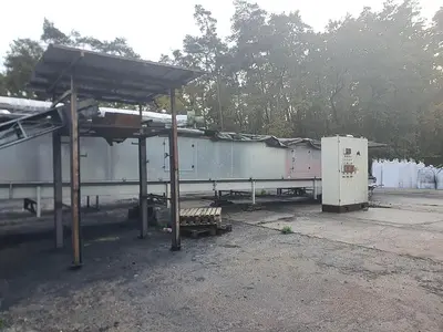 Briquetting machine for the production of charcoal briquettes including a hot air generator and conveyor