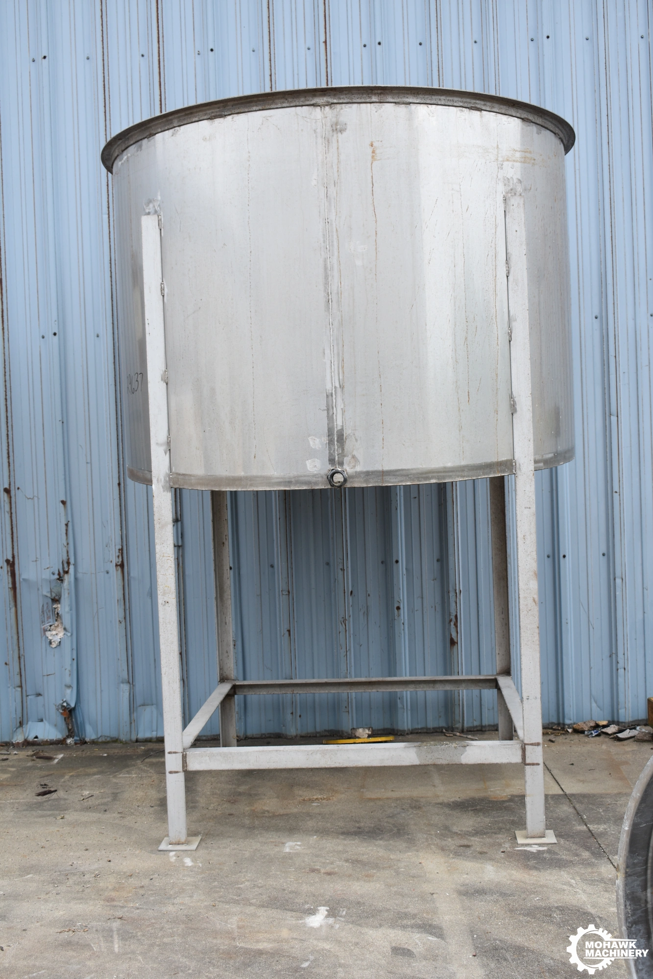1175 GALLON (APPROX) VERTICAL STAINLESS STEEL STORAGE TANK w/STAINLESS STEEL FABRICATED STAND - 80” TANK DIAMETER - 54” TANK HEIGHT - FORWARD TILTING BOTTOM