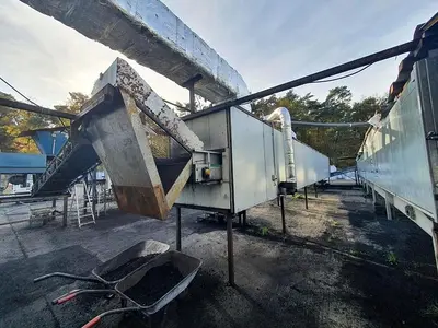 Briquetting machine for the production of charcoal briquettes including a hot air generator and conveyor