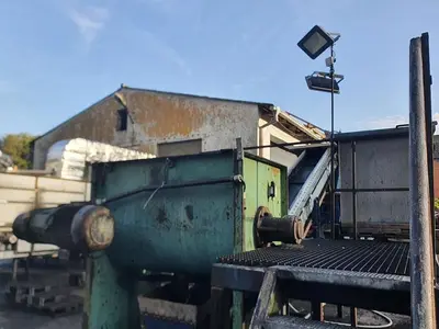 Briquetting machine for the production of charcoal briquettes including a hot air generator and conveyor