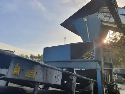 Briquetting machine for the production of charcoal briquettes including a hot air generator and conveyor