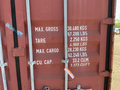 20’ Shipping / Storage Container 8’ wide x 8’ 6” tall, swing doors on one end, wood deck, rings for ...