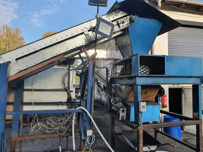 Briquetting machine for the production of charcoal briquettes including a hot air generator and conveyor