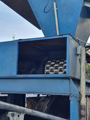 Briquetting machine for the production of charcoal briquettes including a hot air generator and conveyor