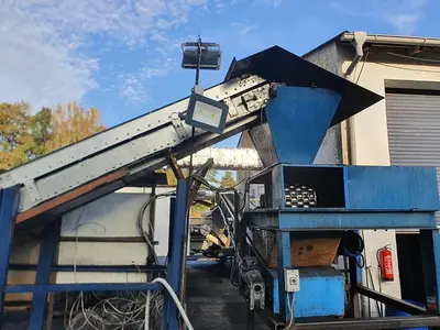 Briquetting machine for the production of charcoal briquettes including a hot air generator and conveyor