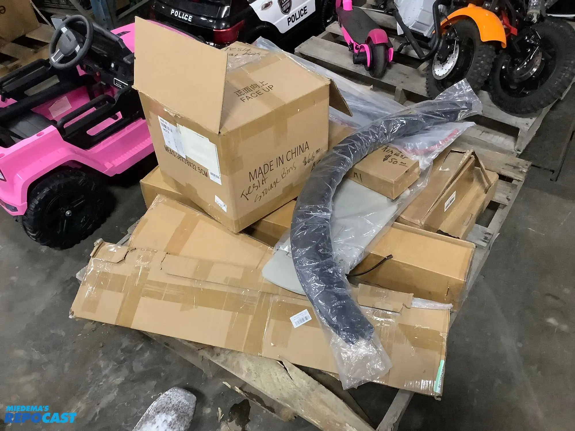 Lot of various car parts including Tesla storage bins, a sunroof deflector, mud flaps, a Colorado...