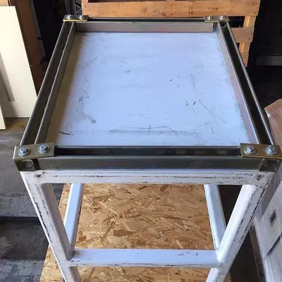 Heavy duty steel frame work tables with adjustable feet.