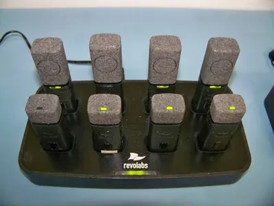 (24) Revolabs Wireless Lapel Mics / Microphones with (3) Charging Bases and (5) Replacement Mics that are NEW IN BOX