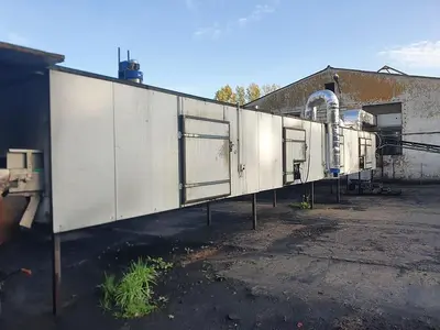 Briquetting machine for the production of charcoal briquettes including a hot air generator and conveyor