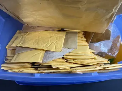 Collection of Padded Mailing Envelopes and Bubble Mailers in Storage Bin