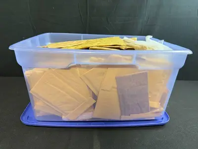 Collection of Padded Mailing Envelopes and Bubble Mailers in Storage Bin