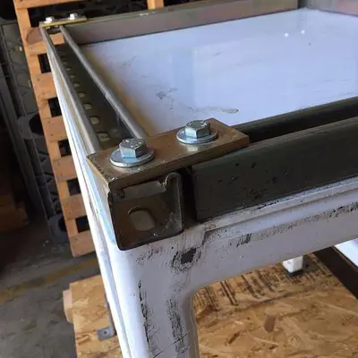 Heavy duty steel frame work tables with adjustable feet.