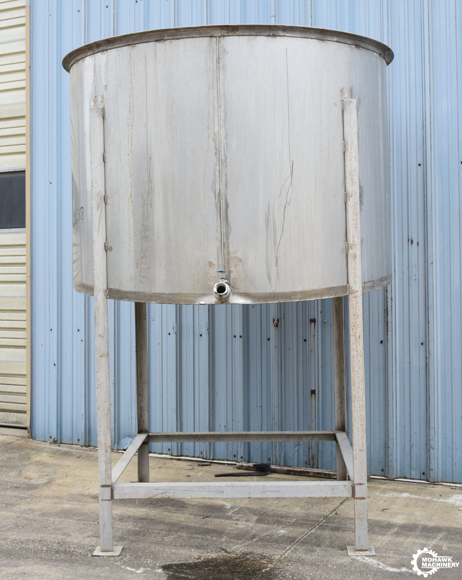 1175 GALLON (APPROX) VERTICAL STAINLESS STEEEL STORAGE TANK w/STAINLESS STEEL FABRICATED STAND - 80” TANK DIAMETER - 54” TANK HEIGHT - FORWARD TILTING BOTTOM