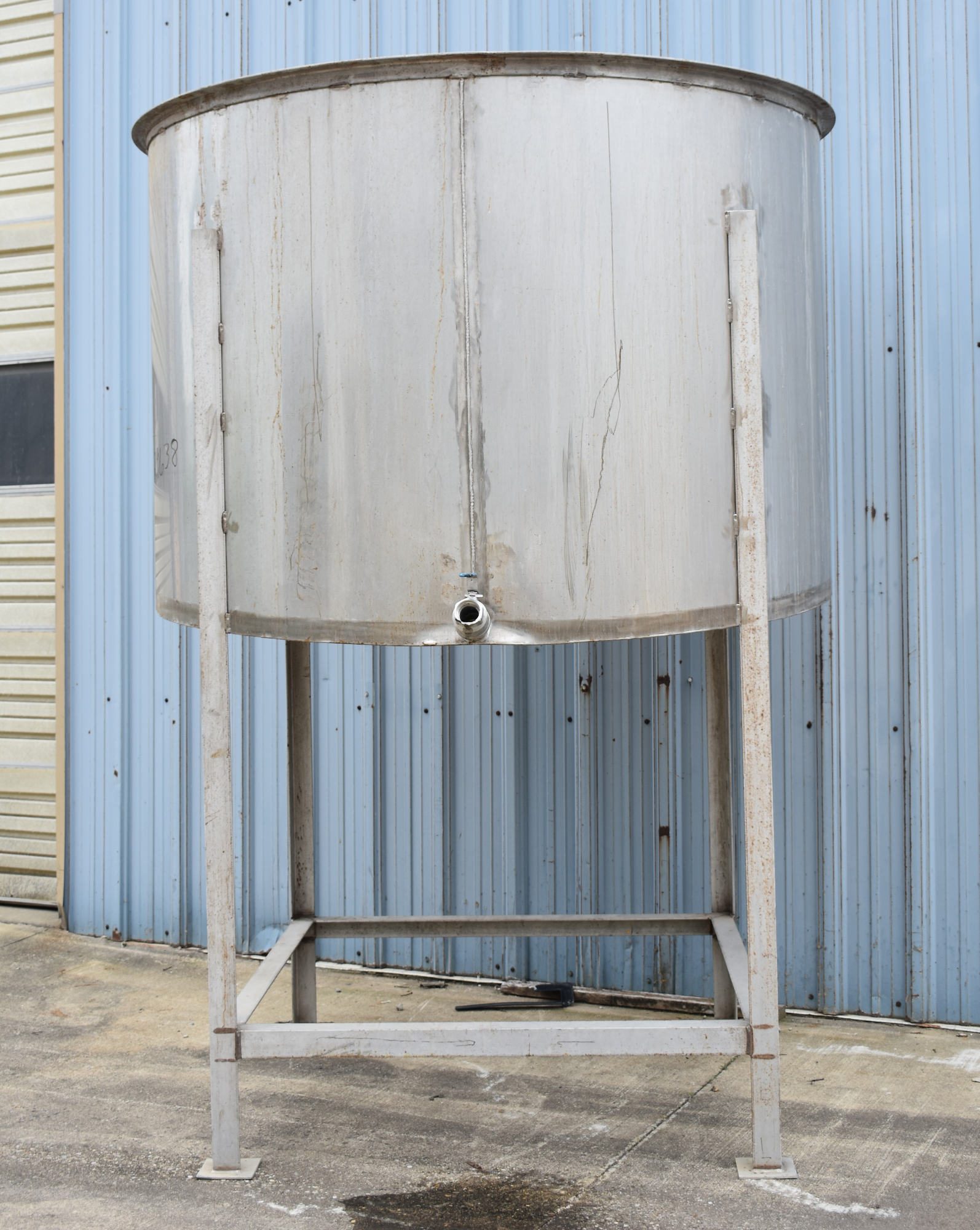 1175 GALLON (APPROX) VERTICAL STAINLESS STEEEL STORAGE TANK w/STAINLESS STEEL FABRICATED STAND - 80” TANK DIAMETER - 54” TANK HEIGHT - FORWARD TILTING BOTTOM