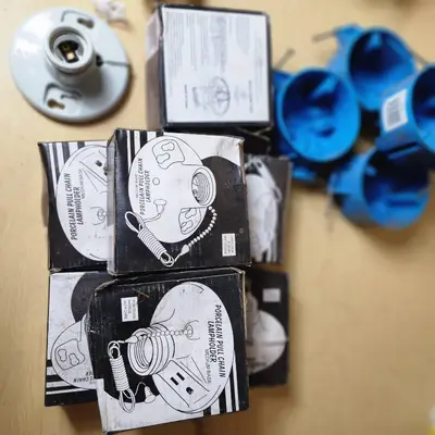 Lot of Electrical Supplies Including Porcelain Pull Chain Lampholders, GE Wall Switch Outlet, and Electrical Boxes