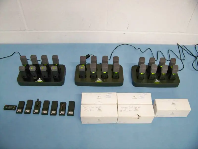 (24) Revolabs Wireless Lapel Mics / Microphones with (3) Charging Bases and (5) Replacement Mics that are NEW IN BOX