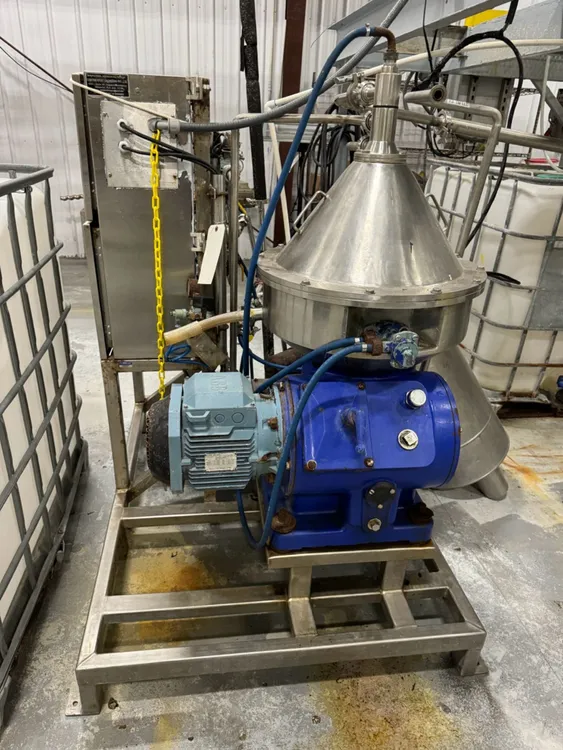 ALFA LAVAL MAB 204S-24-60 stainless-steel disc stack centrifuge on a blue base in a factory.