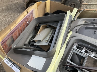 Skid of used semi truck truck interior parts including dash panels, trim, climate control panels, ve...