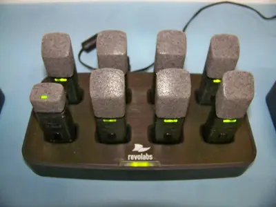 (24) Revolabs Wireless Lapel Mics / Microphones with (3) Charging Bases and (5) Replacement Mics that are NEW IN BOX
