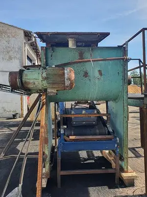 Briquetting machine for the production of charcoal briquettes including a hot air generator and conveyor