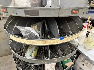(1) 7-tier lazy Susan style parts rack, approx. 66" tall, includes assorted socket head cap screws, ...