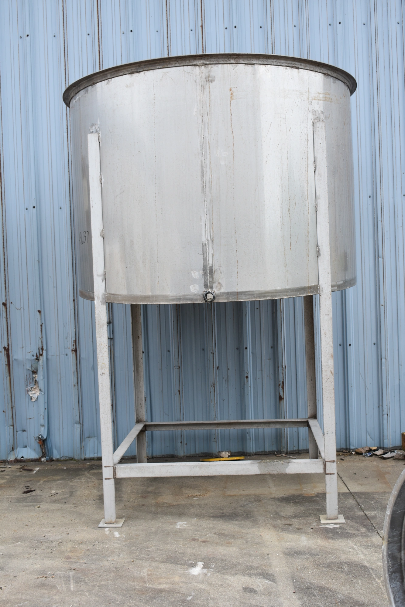 1175 GALLON (APPROX) VERTICAL STAINLESS STEEL STORAGE TANK w/STAINLESS STEEL FABRICATED STAND - 80” TANK DIAMETER - 54” TANK HEIGHT - FORWARD TILTING BOTTOM
