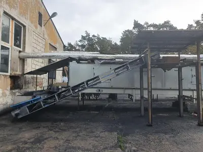 Briquetting machine for the production of charcoal briquettes including a hot air generator and conveyor