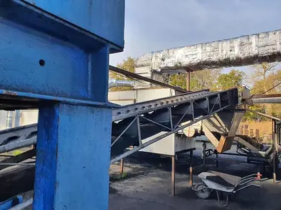 Briquetting machine for the production of charcoal briquettes including a hot air generator and conveyor